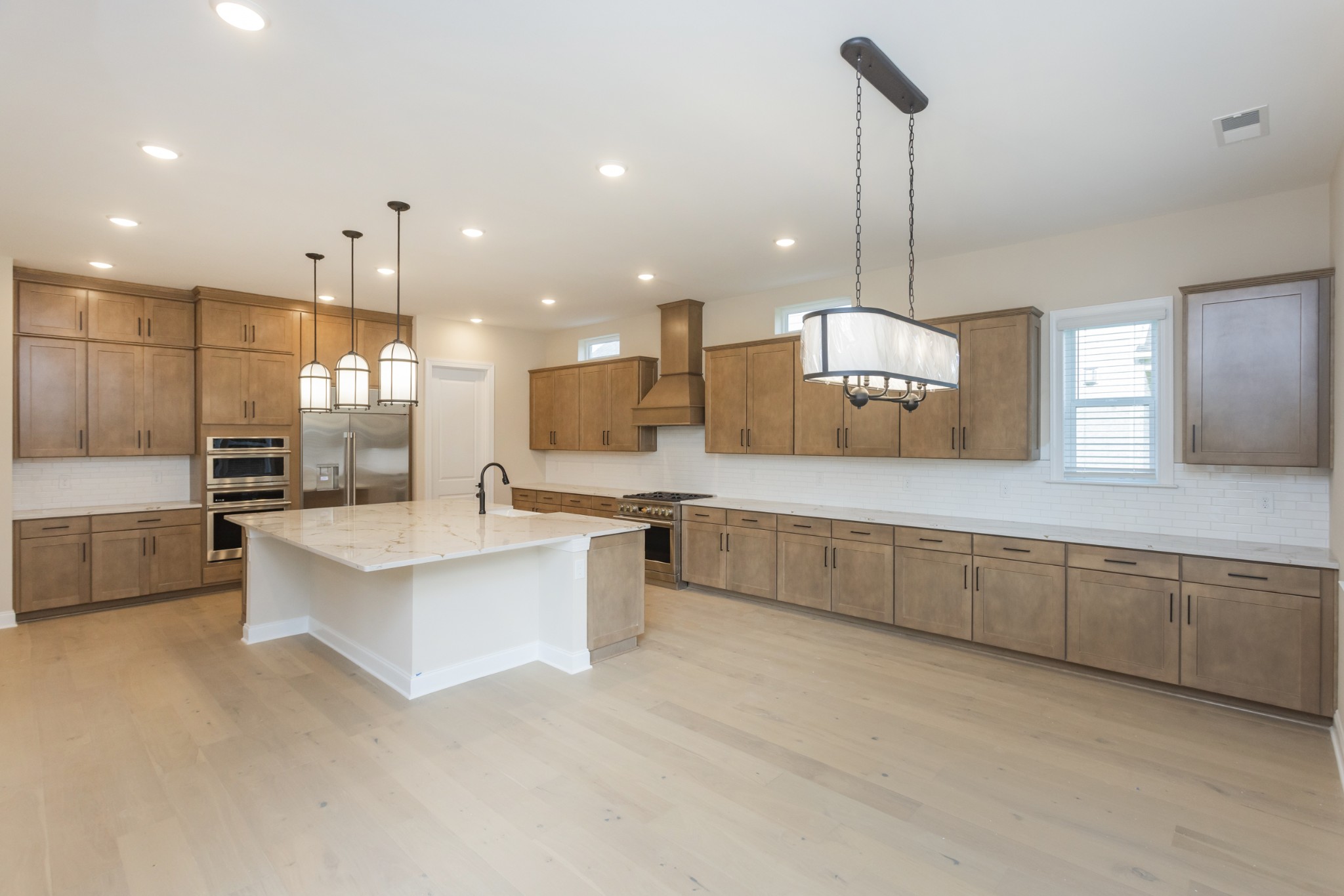 7006 Thunderhead Way Spring Hill, TN 37174 - Photo 21 of 58 a large kitchen with kitchen island a sink stainless steel appliances and white cabinets