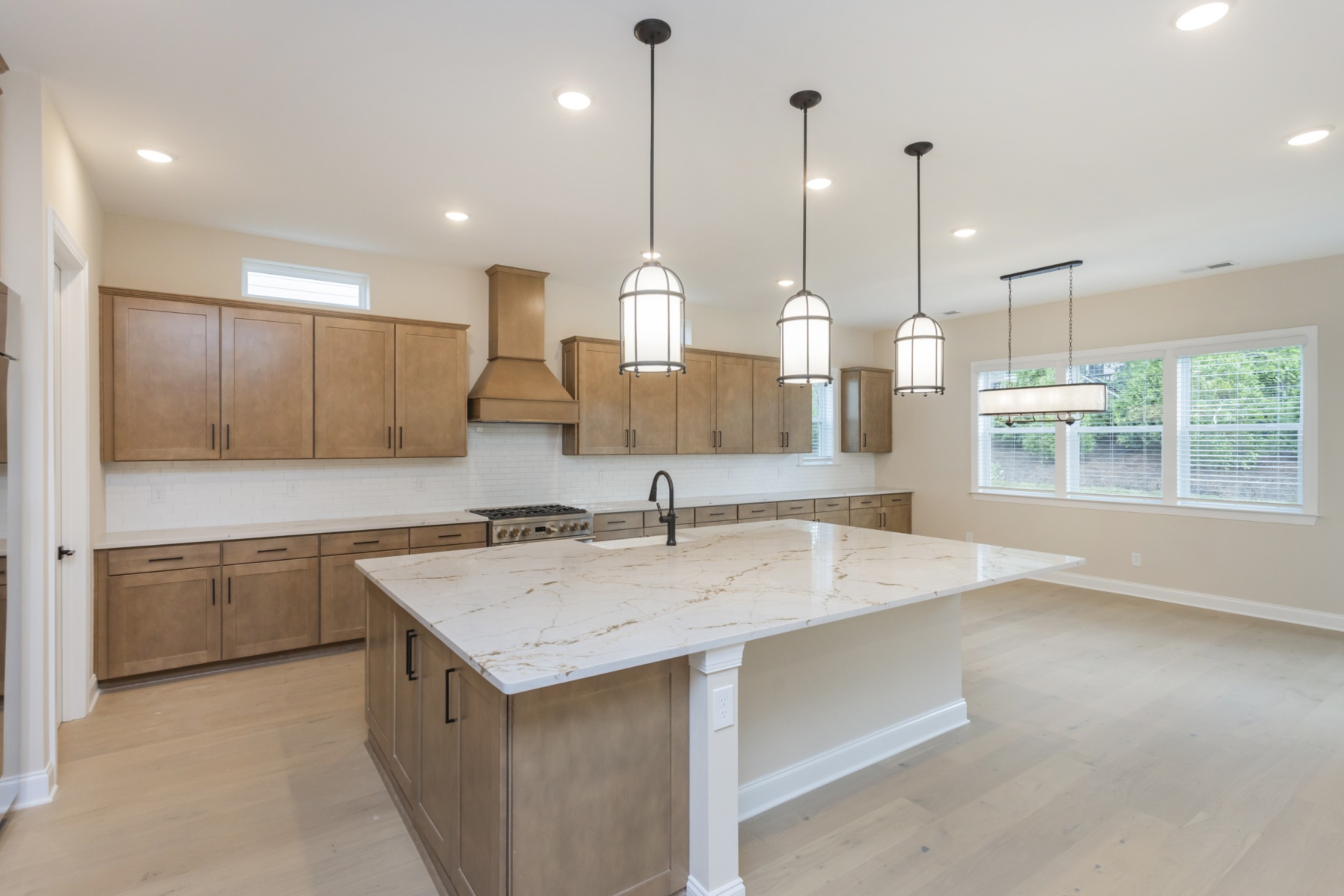 7006 Thunderhead Way Spring Hill, TN 37174 - Photo 23 of 58 a kitchen with a sink a center island cabinets and a wooden floor