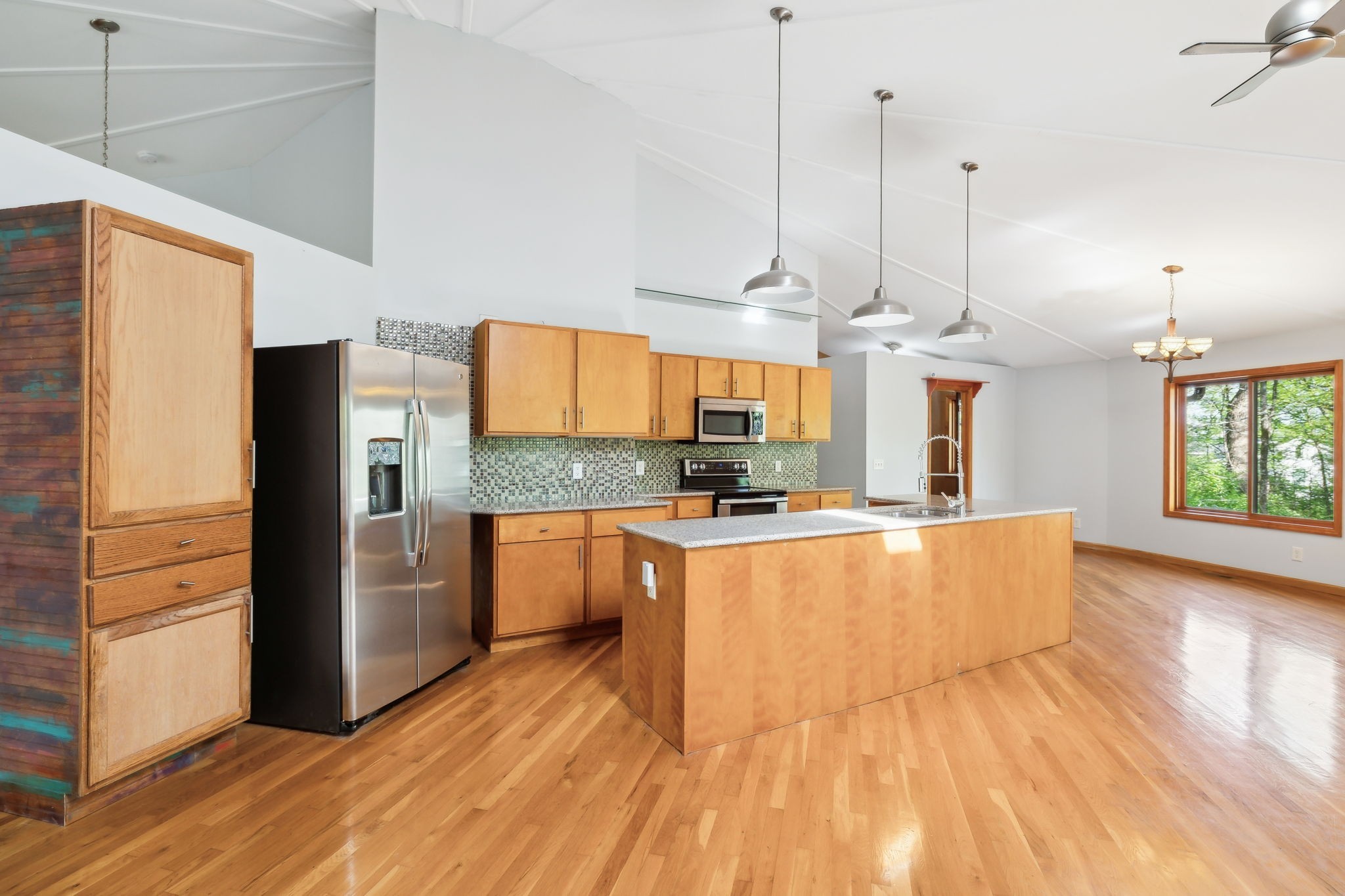 3055 Smith Springs Road Antioch, TN 37013 - Photo 15 of 59 a large kitchen with stainless steel appliances kitchen island granite countertop a refrigerator a oven a island and couches with wooden floor