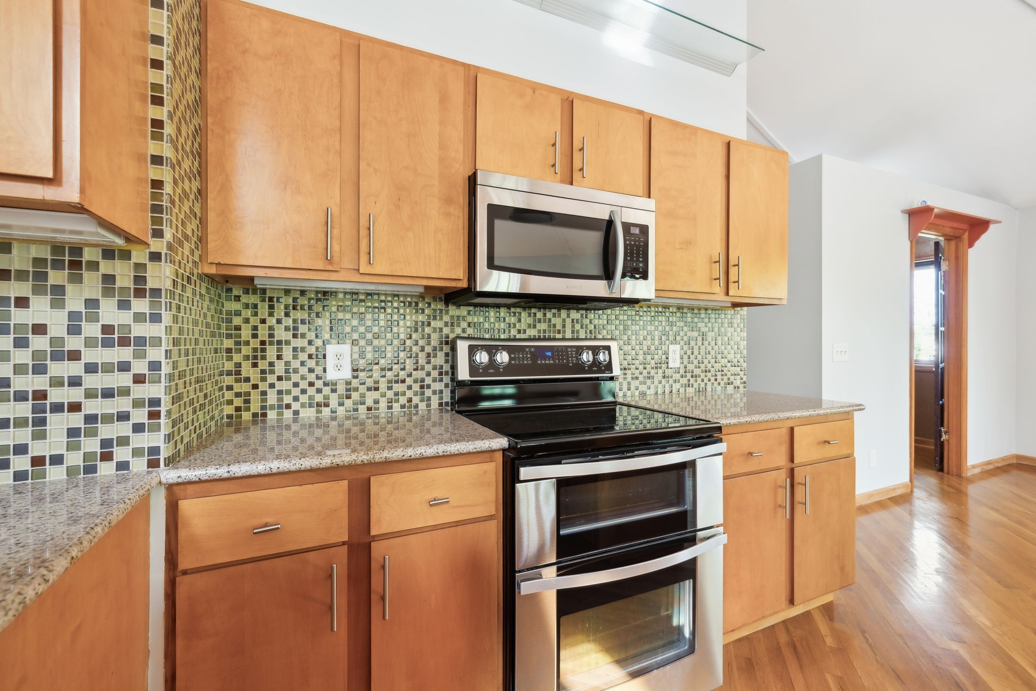 3055 Smith Springs Road Antioch, TN 37013 - Photo 22 of 59 a kitchen with stainless steel appliances granite countertop a stove microwave and cabinets