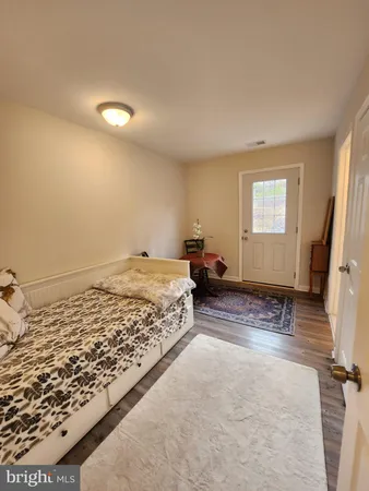 a spacious bedroom with a bed and wooden floor