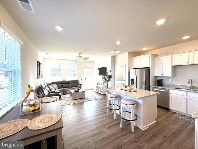 a living room with stainless steel appliances kitchen island granite countertop furniture and a kitchen view