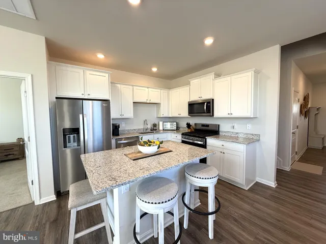 a living room with furniture kitchen view and a chandelier