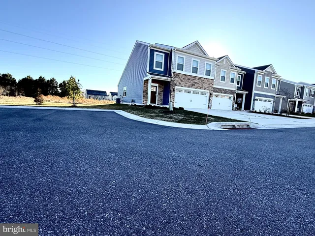 a view of a white house with large windows and a yard