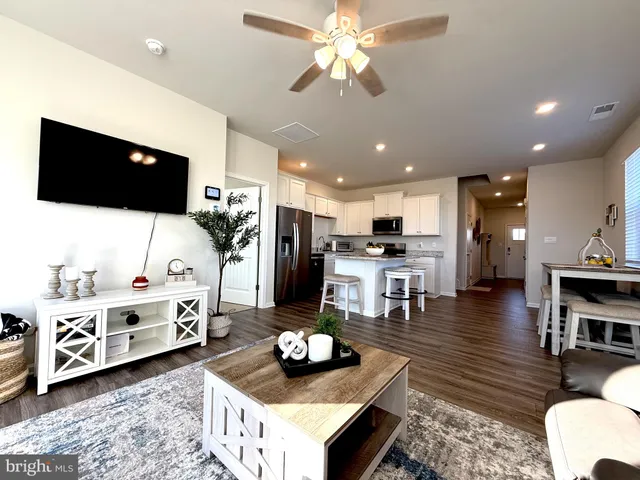 a view of a hallway with wooden floor and a living room