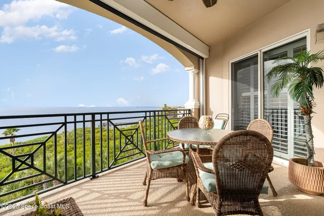a balcony with table and chairs