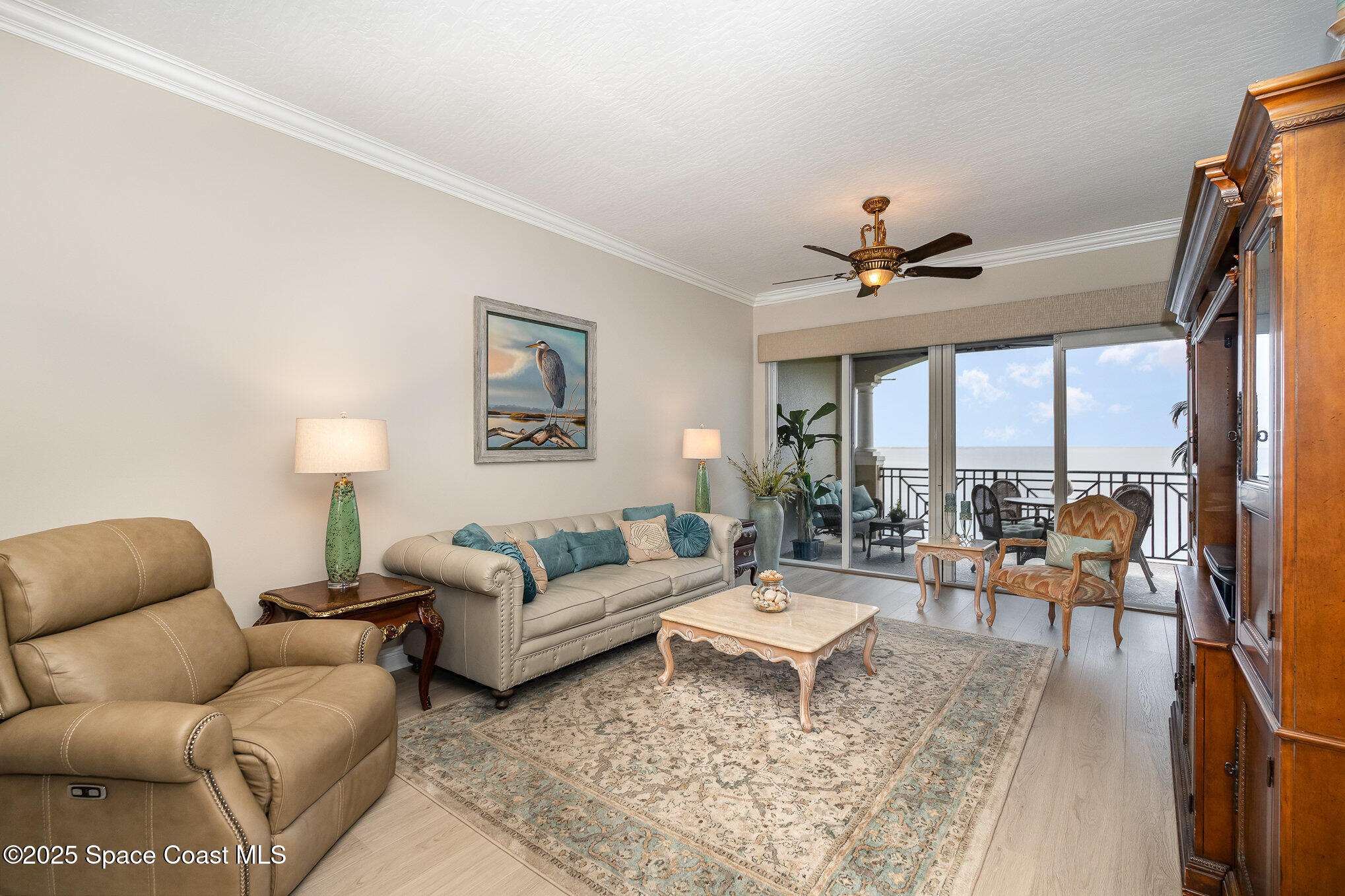 2022 Julep Drive, Unit 304 Cocoa Beach, FL 32931 - Photo 4 of 34 a living room with furniture ceiling fan and a large window