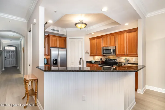 a kitchen with stainless steel appliances granite countertop a sink a stove and a refrigerator