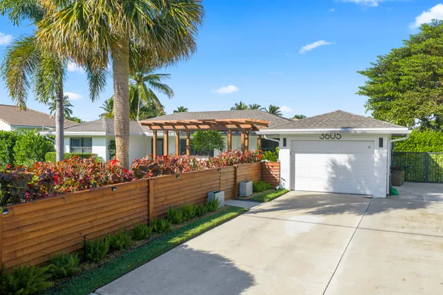 a view of a house with a yard and potted plants