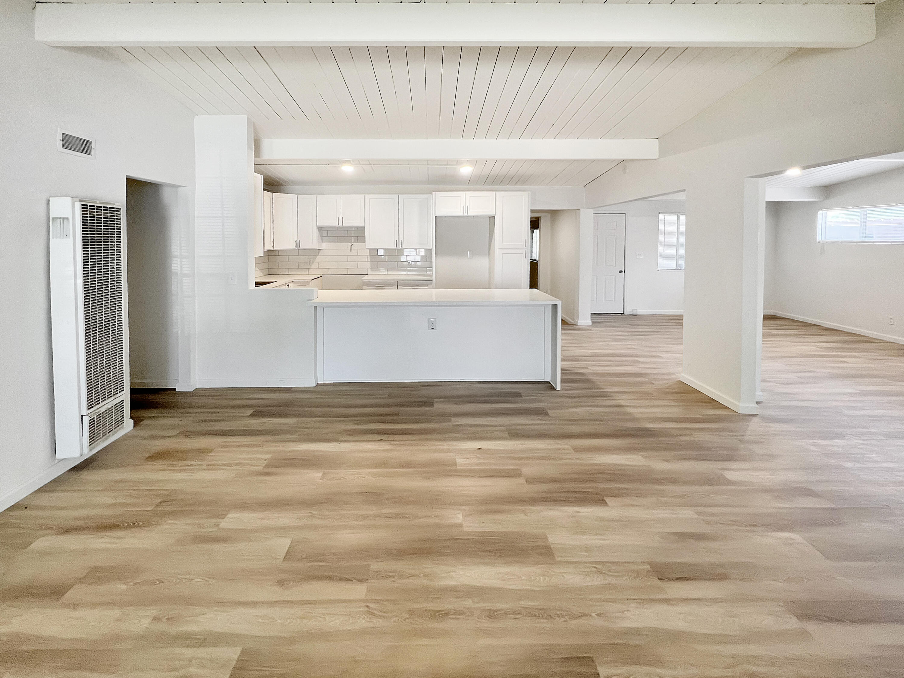 1226 Ave H 15 Lancaster, CA 93534 - Photo 4 of 15 a view of kitchen and empty room with wooden floor