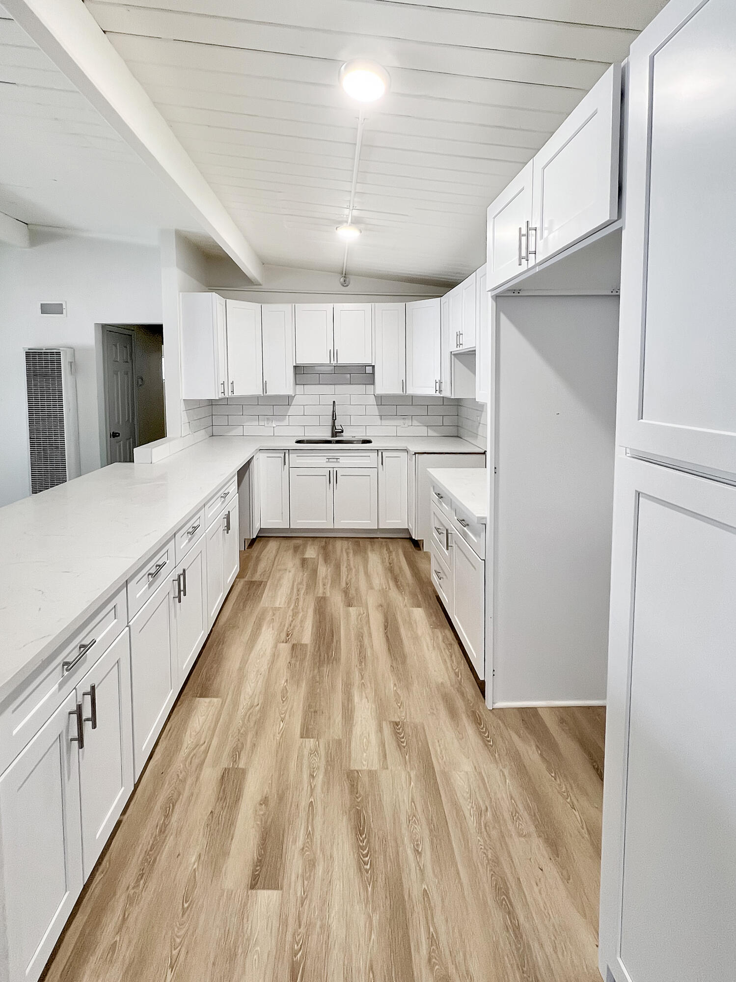 1226 Ave H 15 Lancaster, CA 93534 - Photo 8 of 15 a large kitchen with kitchen island white cabinets and stainless steel appliances