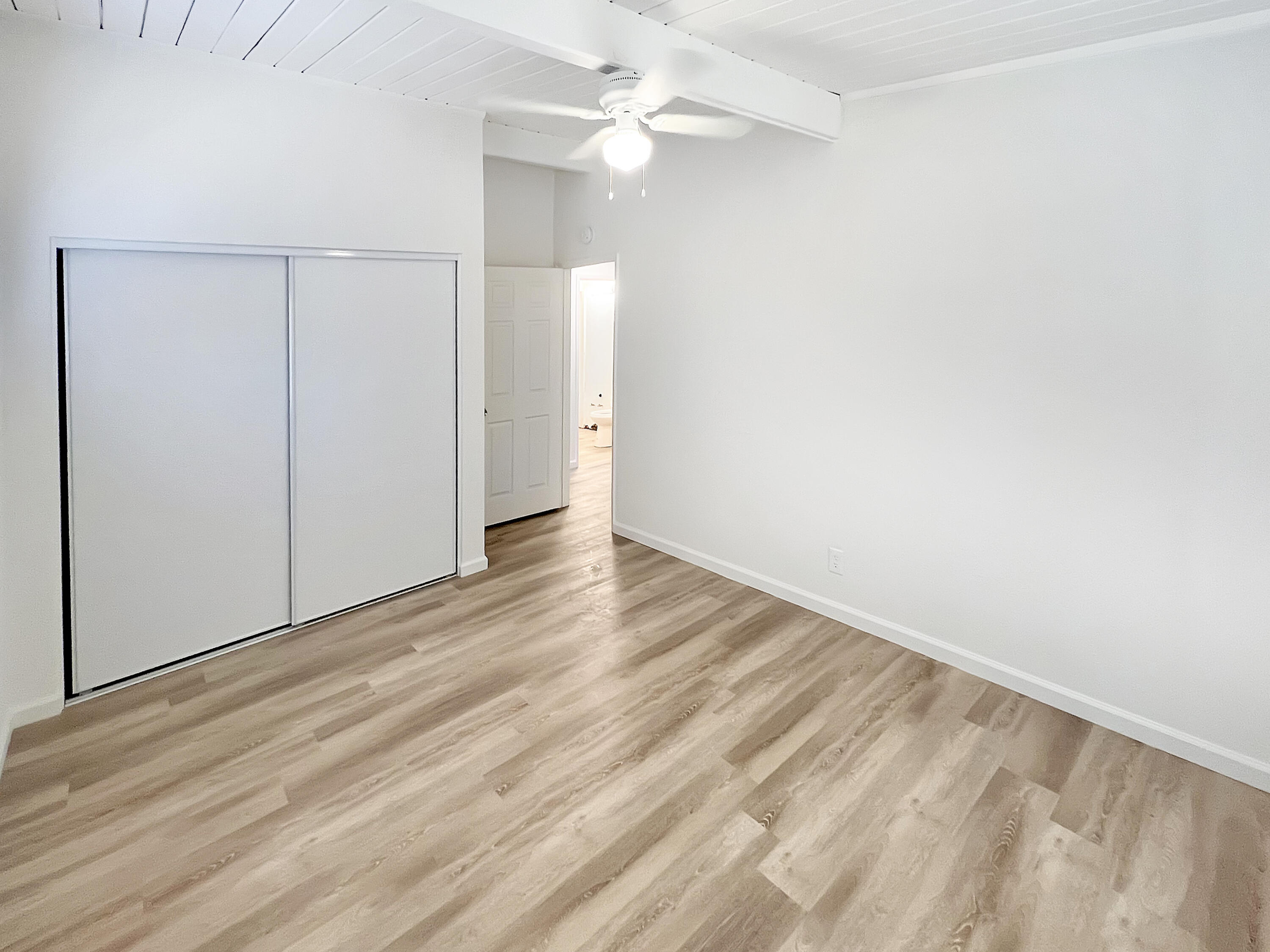 1226 Ave H 15 Lancaster, CA 93534 - Photo 10 of 15 an empty room with wooden floor and fan