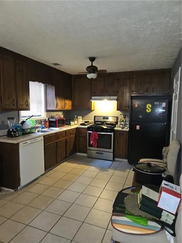 a kitchen with stainless steel appliances kitchen island granite countertop a sink cabinets and a stove top oven