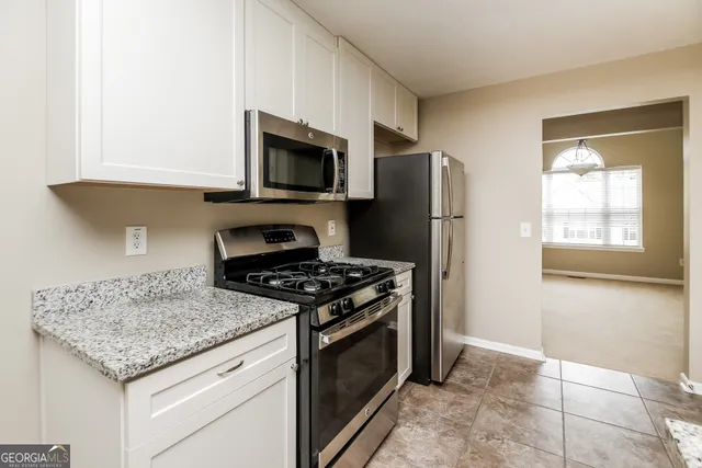 a kitchen with granite countertop a stove and a microwave