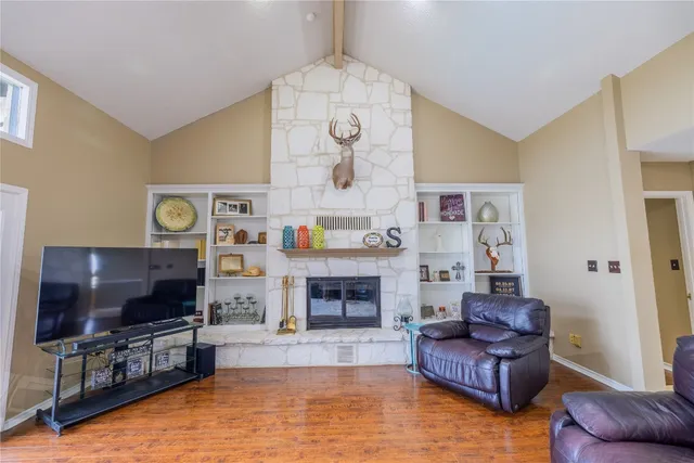 a living room with furniture a flat screen tv and a fireplace