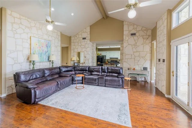 a living room with furniture kitchen view and a chandelier