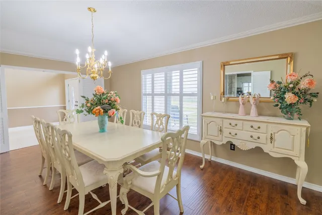 a kitchen with stainless steel appliances a refrigerator a stove a sink dishwasher and a dining table with wooden floor