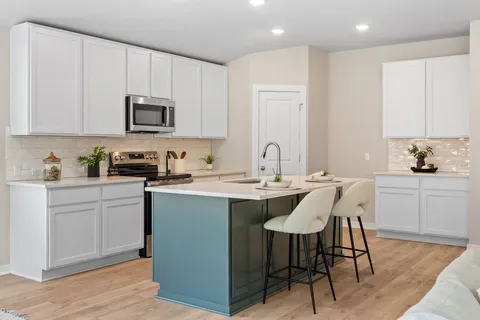 a kitchen with stainless steel appliances granite countertop a sink a stove a microwave a refrigerator and cabinets