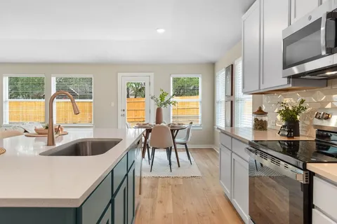 a kitchen with granite countertop a sink and a stove top oven