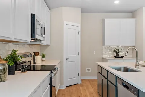 a kitchen with a sink dishwasher a stove and a refrigerator with wooden floor