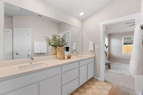 a bathroom with double vanity sinks and a mirror