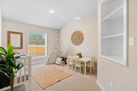 a living room with furniture a potted plant and a large window