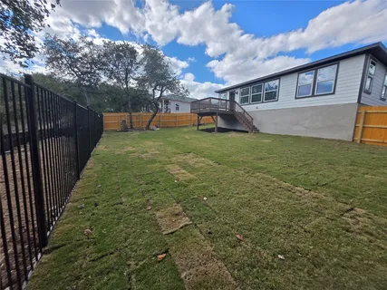 a view of a house with backyard and a tree