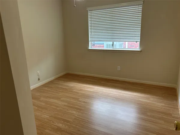 an empty room with wooden floor and a window