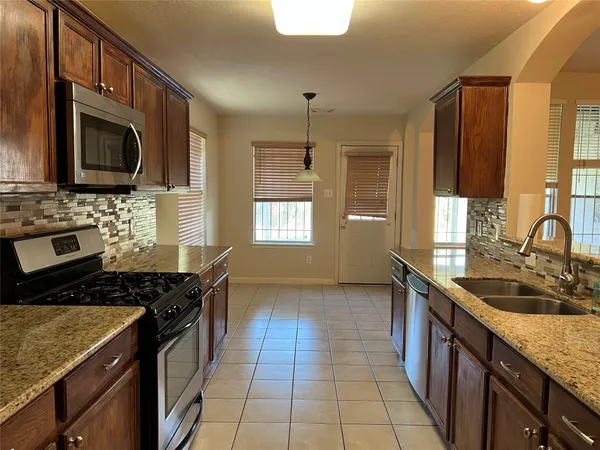 a kitchen with a sink stove top oven and microwave