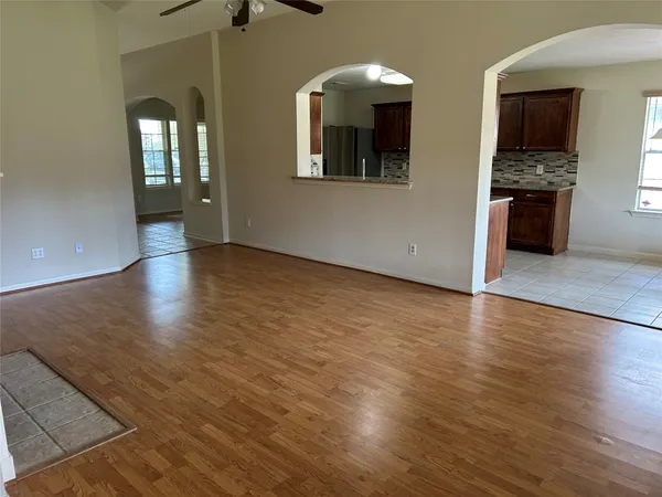 an empty room with wooden floor and a fireplace