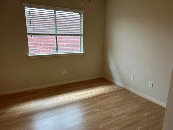 an empty room with wooden floor and a window