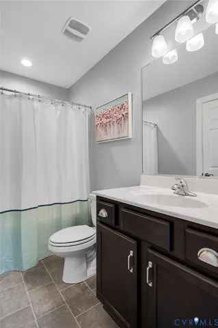 a bathroom with a sink a toilet a mirror and vanity