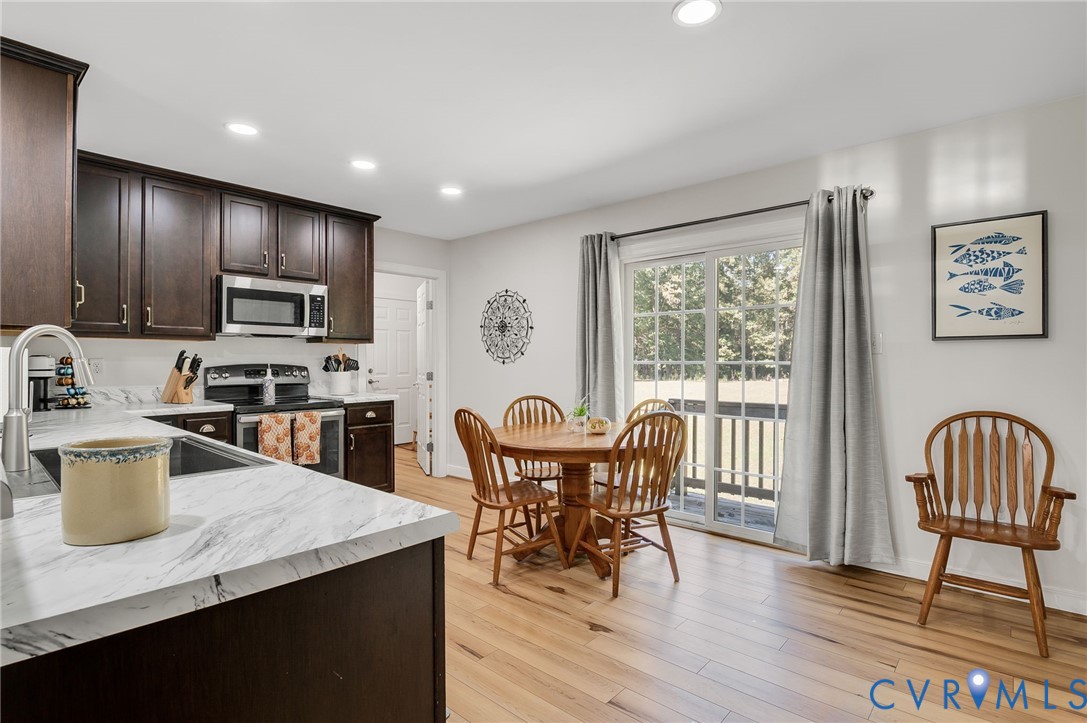 4990 Scandia Road Sandston, VA 23150 - Photo 6 of 25 a kitchen with a dining table chairs and refrigerator