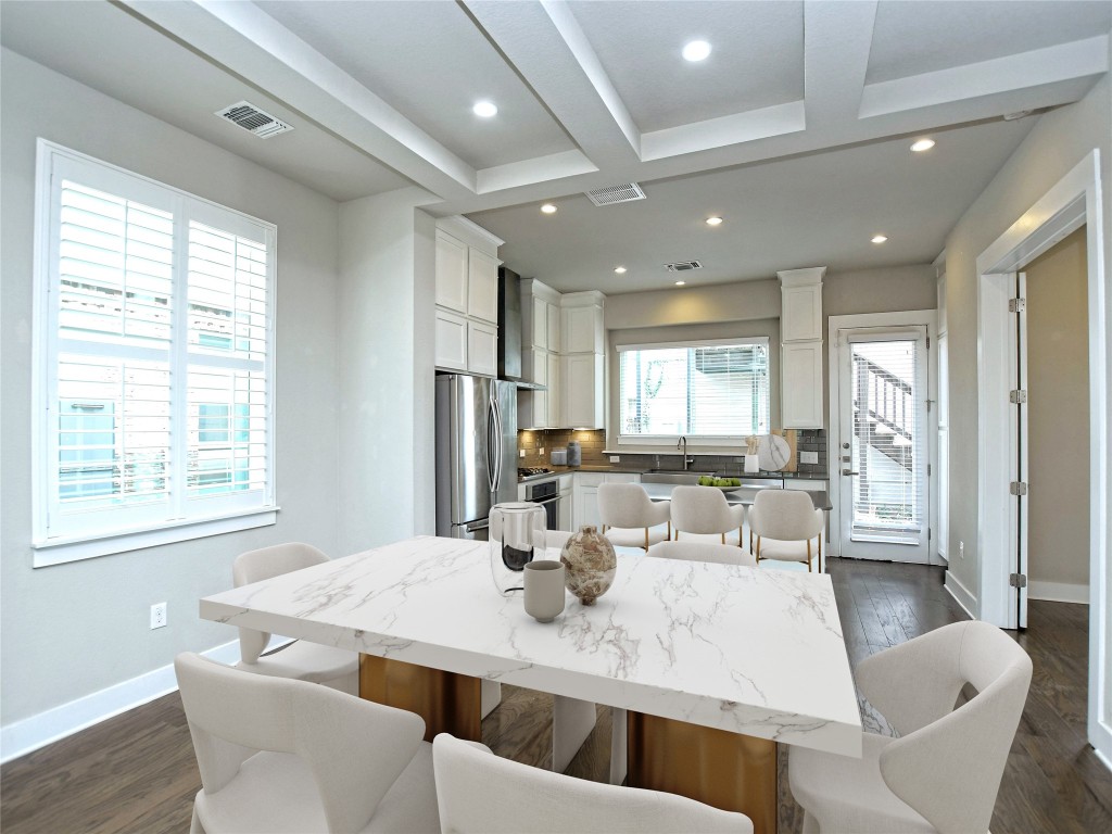 7509 Wildcat Pass Austin, TX 78757 - Photo 13 of 38 Kitchen featuring dark wood finished floors, a breakfast bar, backsplash, white cabinets, and appliances with stainless steel finishes