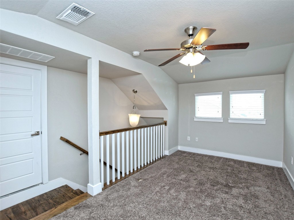 7509 Wildcat Pass Austin, TX 78757 - Photo 28 of 38 Unfurnished room with vaulted ceiling, carpet floors, ceiling fan, and a textured ceiling