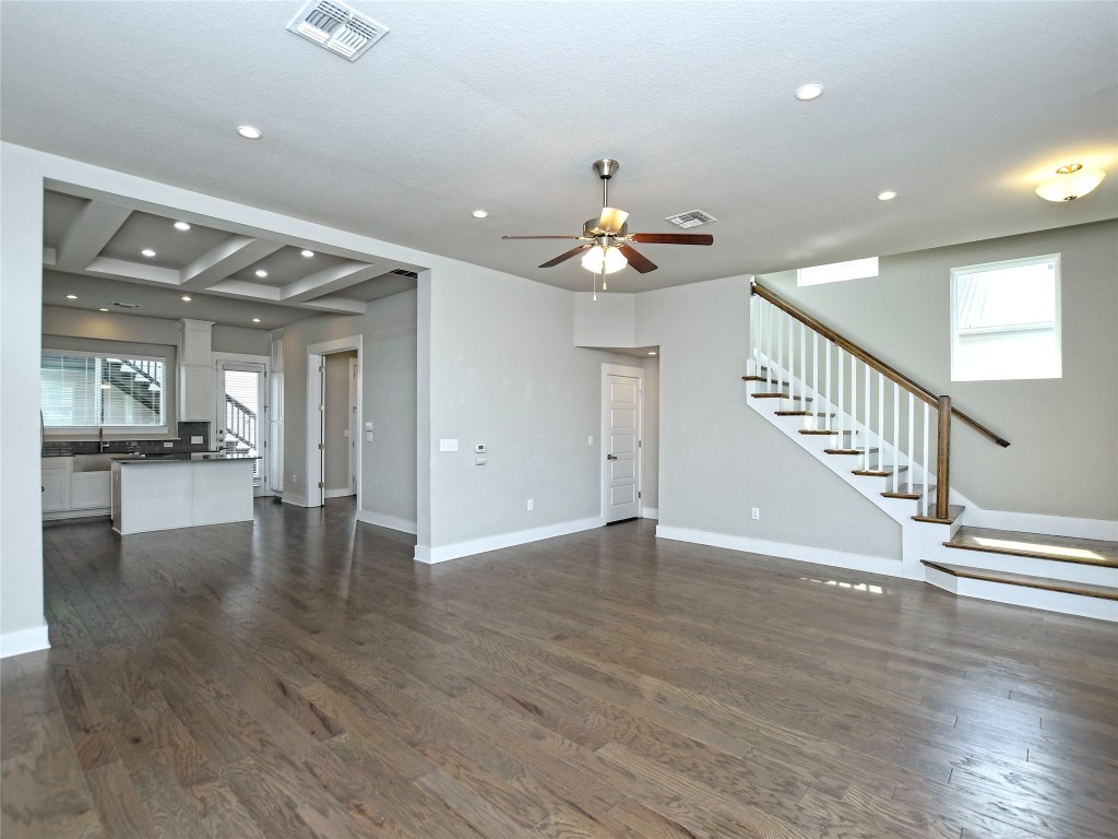 7509 Wildcat Pass Austin, TX 78757 - Photo 7 of 38 Unfurnished living room with stairs, dark wood finished floors, beamed ceiling, ceiling fan, and recessed lighting