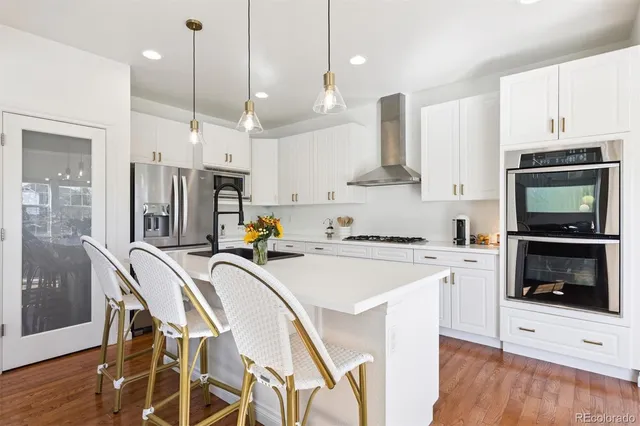 a kitchen that has a lot of cabinets and wooden floor
