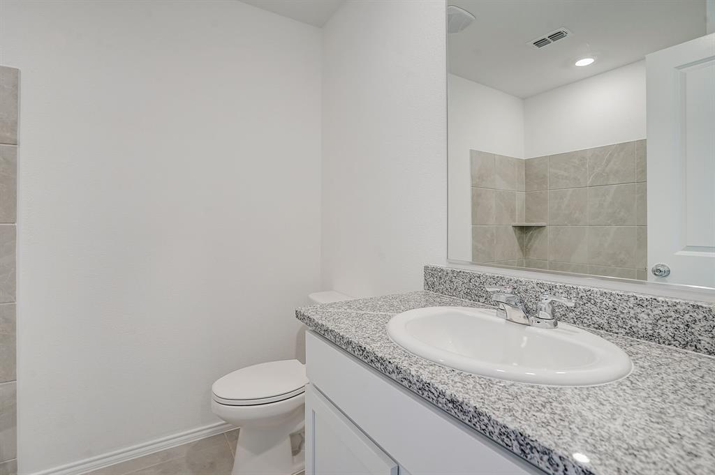2817 Watchpoint Road Little Elm, TX 75068 - Photo 35 of 40 a bathroom with a granite countertop sink a toilet and a mirror