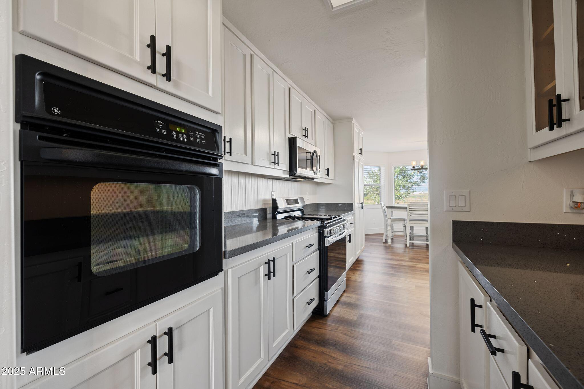 25090 North High Desert Road Paulden, AZ 86334 - Photo 22 of 54 a kitchen with stainless steel appliances a stove microwave and cabinets