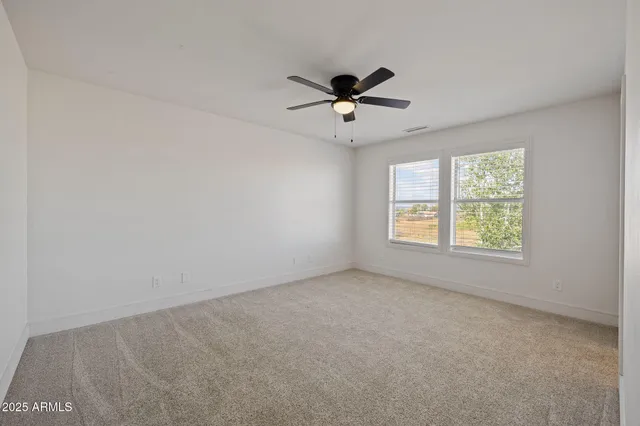 a view of empty room with ceiling fan