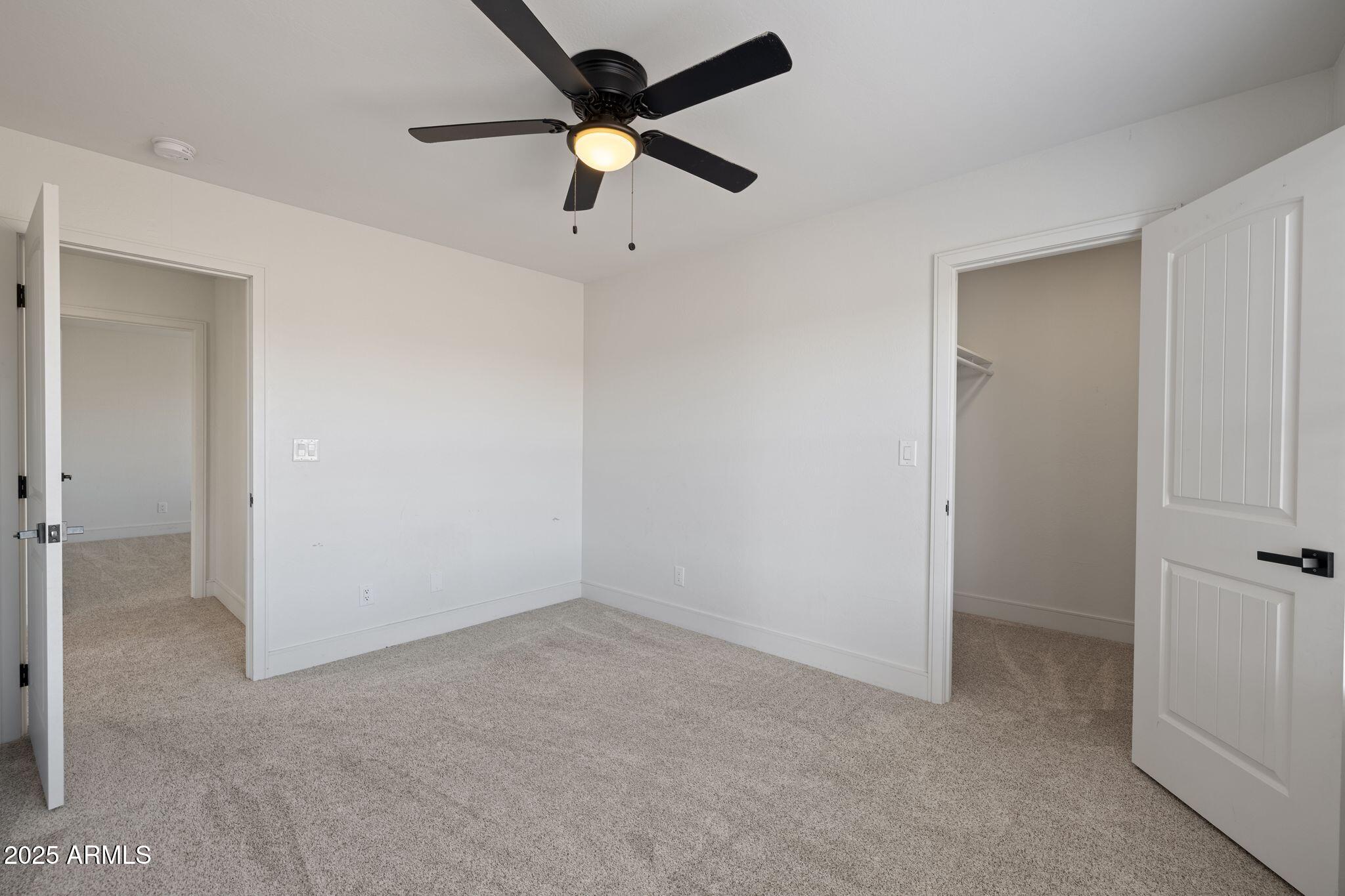 25090 North High Desert Road Paulden, AZ 86334 - Photo 37 of 54 an empty room with a ceiling fan and carpet