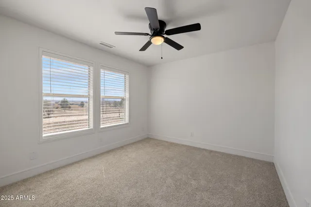 a view of a livingroom with a ceiling fan and window