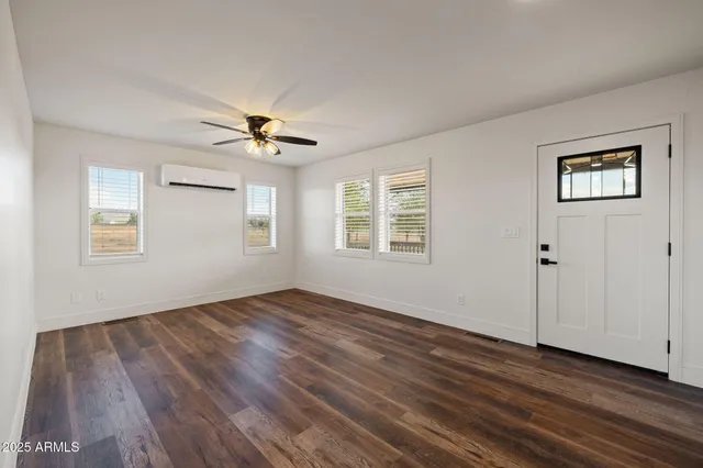a view of empty room with wooden floor and ceiling fan