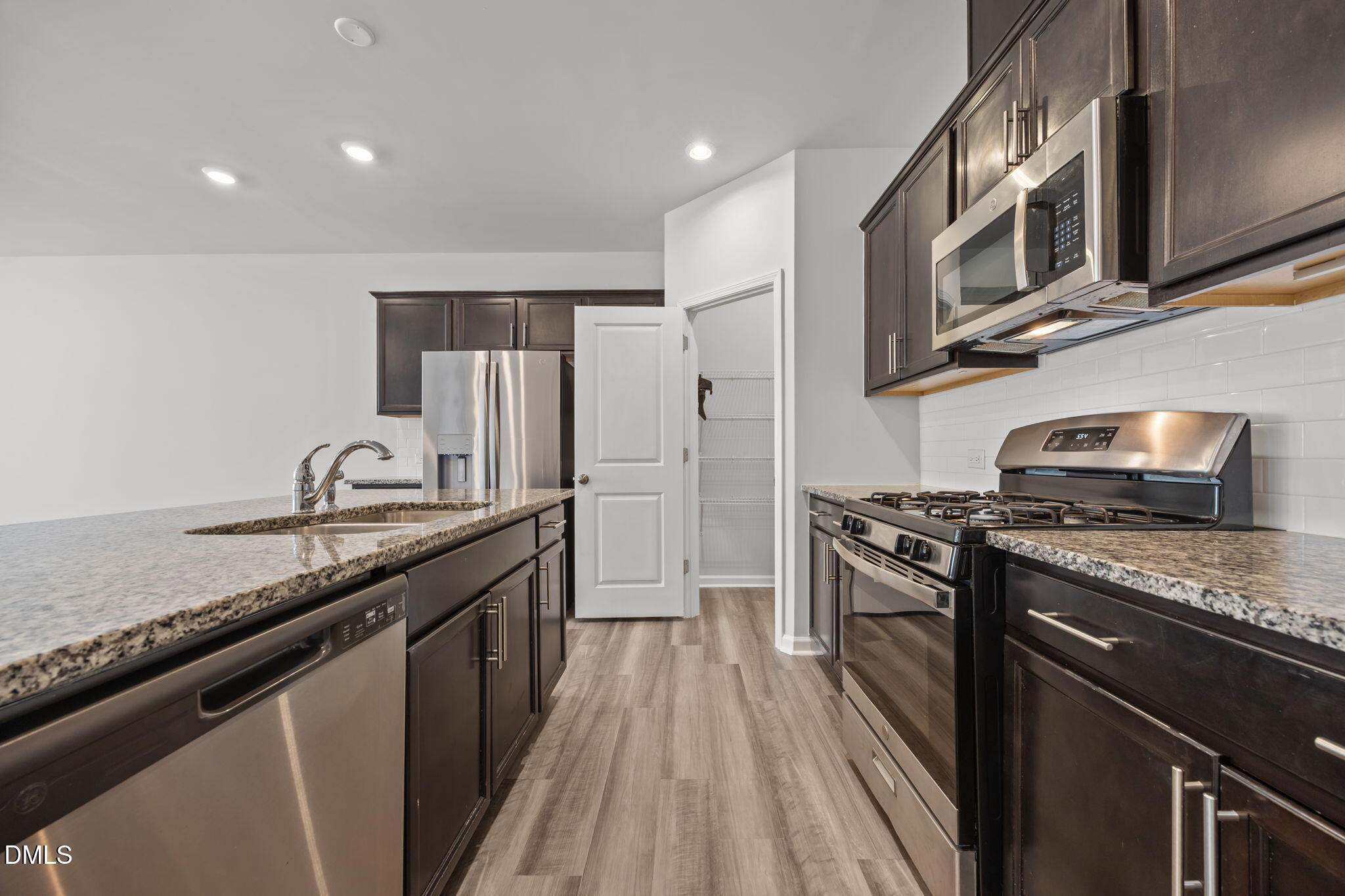 2402 Chert Lane Raleigh, NC 27610 - Photo 12 of 65 a kitchen with stainless steel appliances granite countertop a stove a sink and a refrigerator