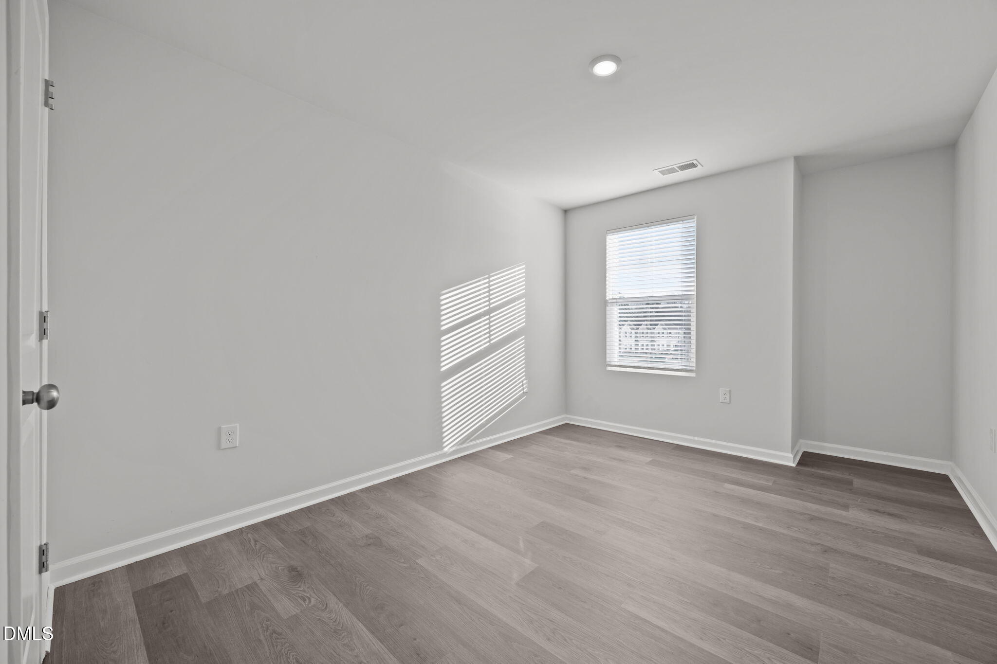 2402 Chert Lane Raleigh, NC 27610 - Photo 27 of 65 an empty room with wooden floor and windows