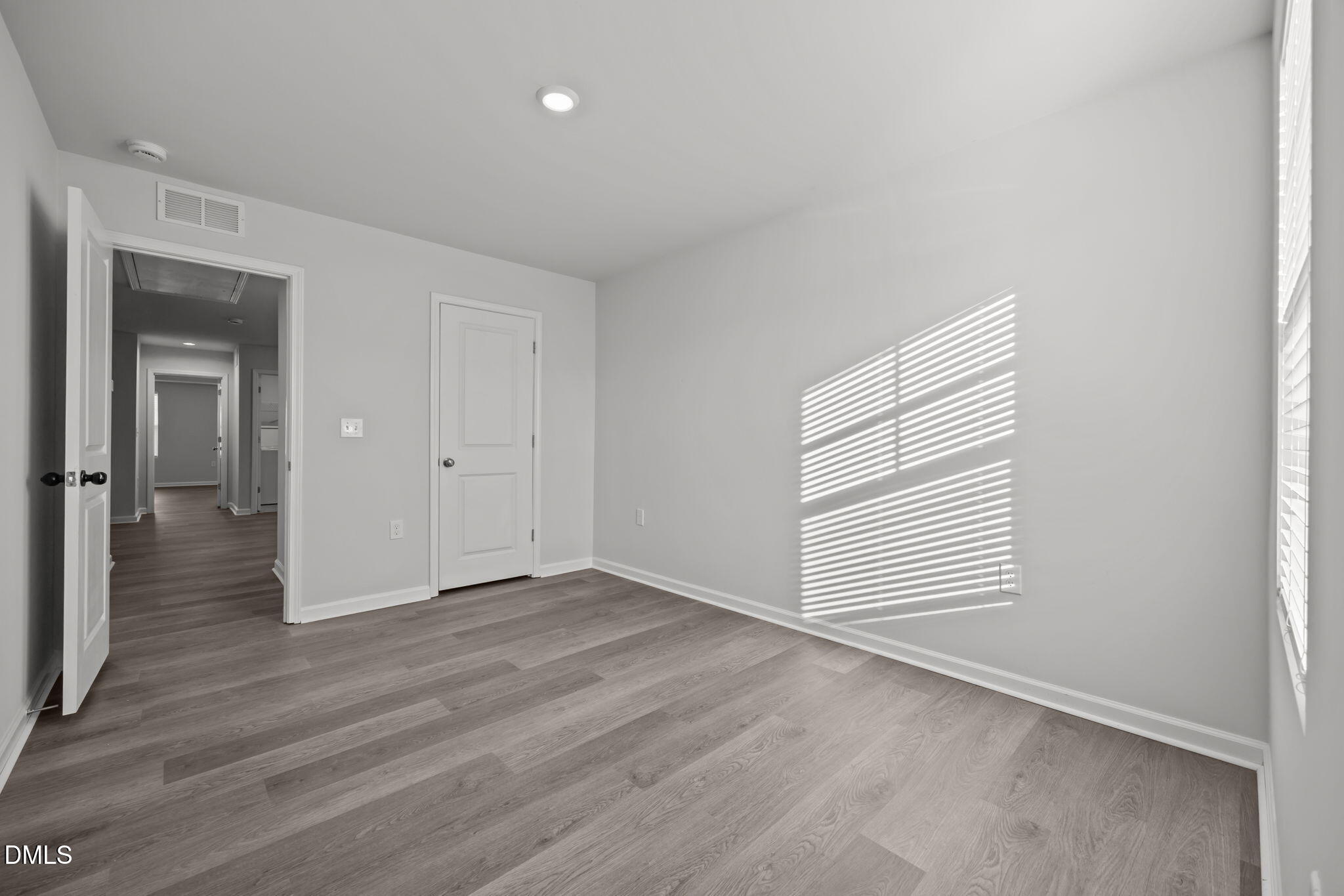 2402 Chert Lane Raleigh, NC 27610 - Photo 28 of 65 an empty room with wooden floor and windows