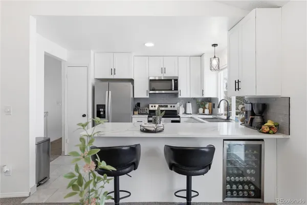 a kitchen with refrigerator and white cabinets