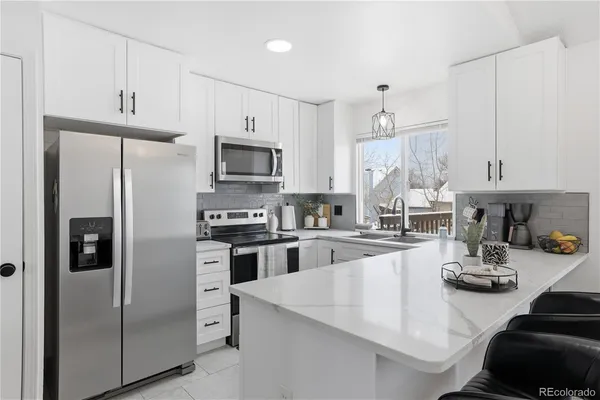 a kitchen with white cabinets and sink