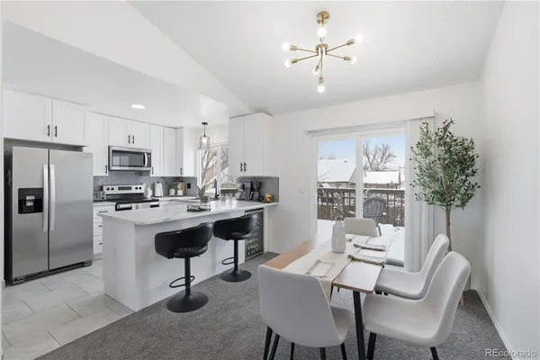 a kitchen with a sink a refrigerator and white cabinets