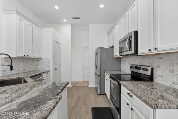 a kitchen with a sink stove and refrigerator
